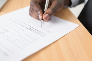 Tay cầm bút ký vào bản hợp đồng